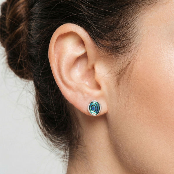 Close-up of an ear wearing a colorful earring with a blurred background