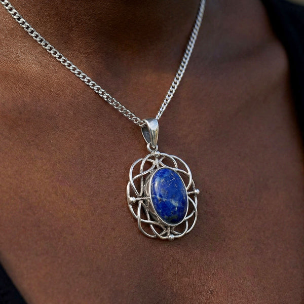 Silver necklace with a blue pendant on a person's neck