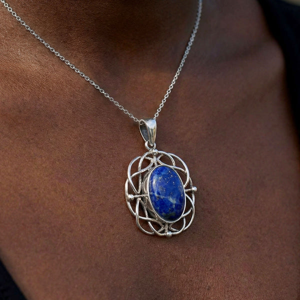 Silver necklace with a blue pendant on a person's neck