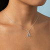 Silver necklace with a Celtic knot pendant on a person against a light blue background