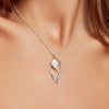 Silver necklace with a leaf-shaped pendant on a model